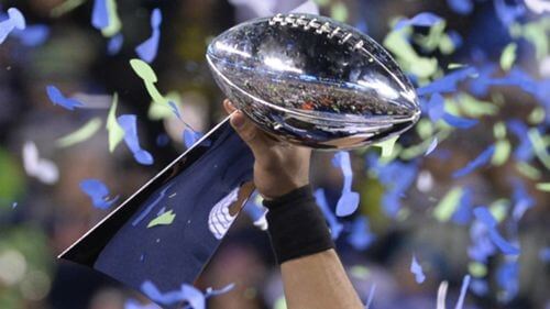 Photographic image of the Super Bowl trophy being lifted in celebration.