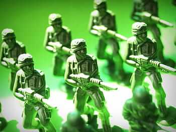 Photograph of toy soldiers posed with guns drawn.