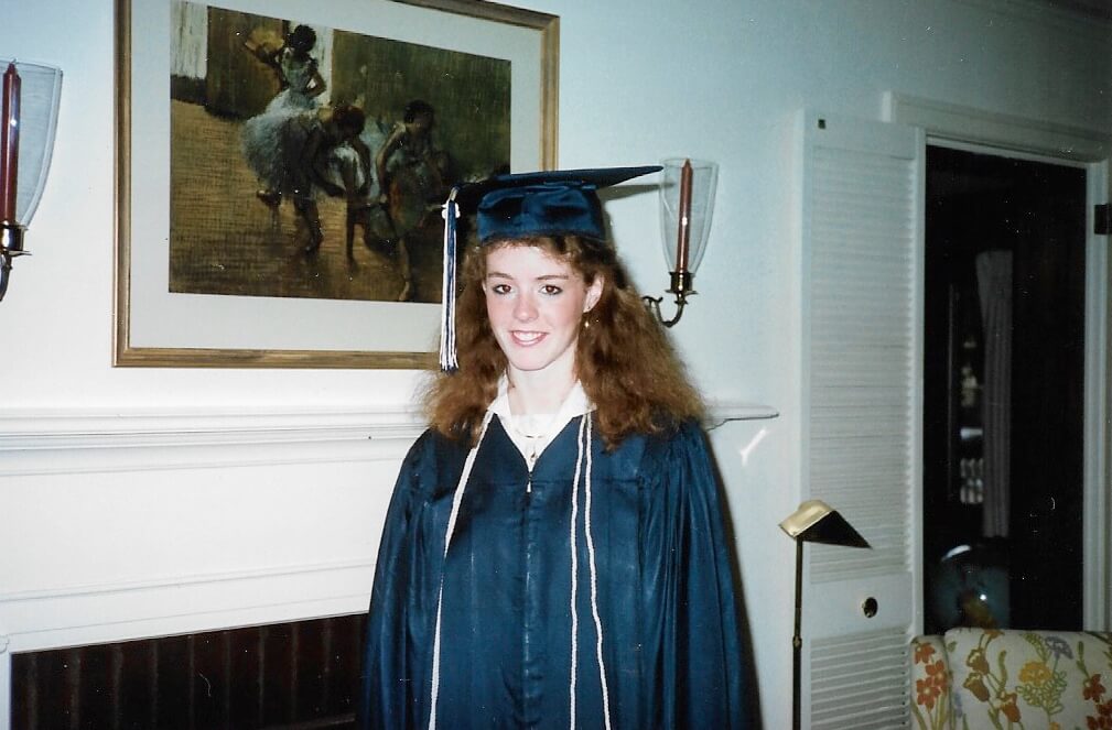 Amy Colton on her graduation day wearing graduation robes and mortar board hat.