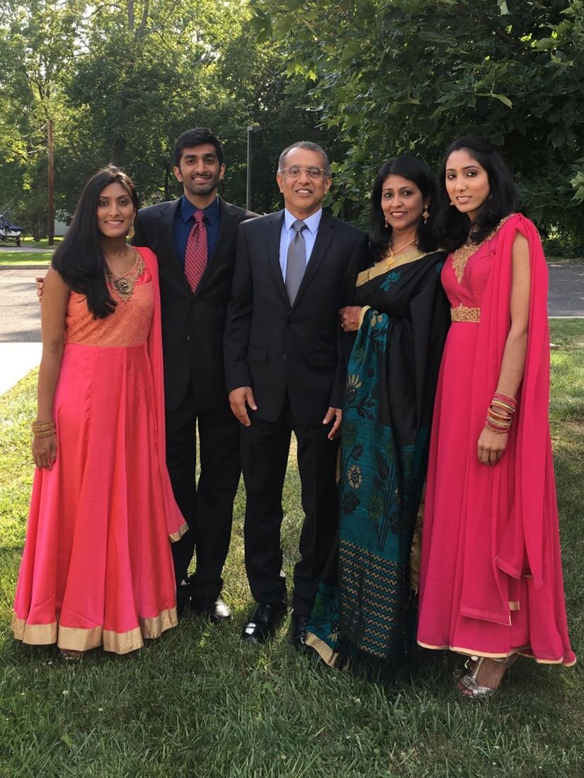 This is a picture of my immediate family. From left to right, it is me; my brother Joseph Pottackal; my dad Joe Pottackal; my mom Selin Pottackal; and my sister Lisha Pottackal. The men are wearing suits, and the women are wearing traditional Indian clothing. My sister and I are wearing pink and gold churidars, and my mom is wearing a black, blue, and gold saree.